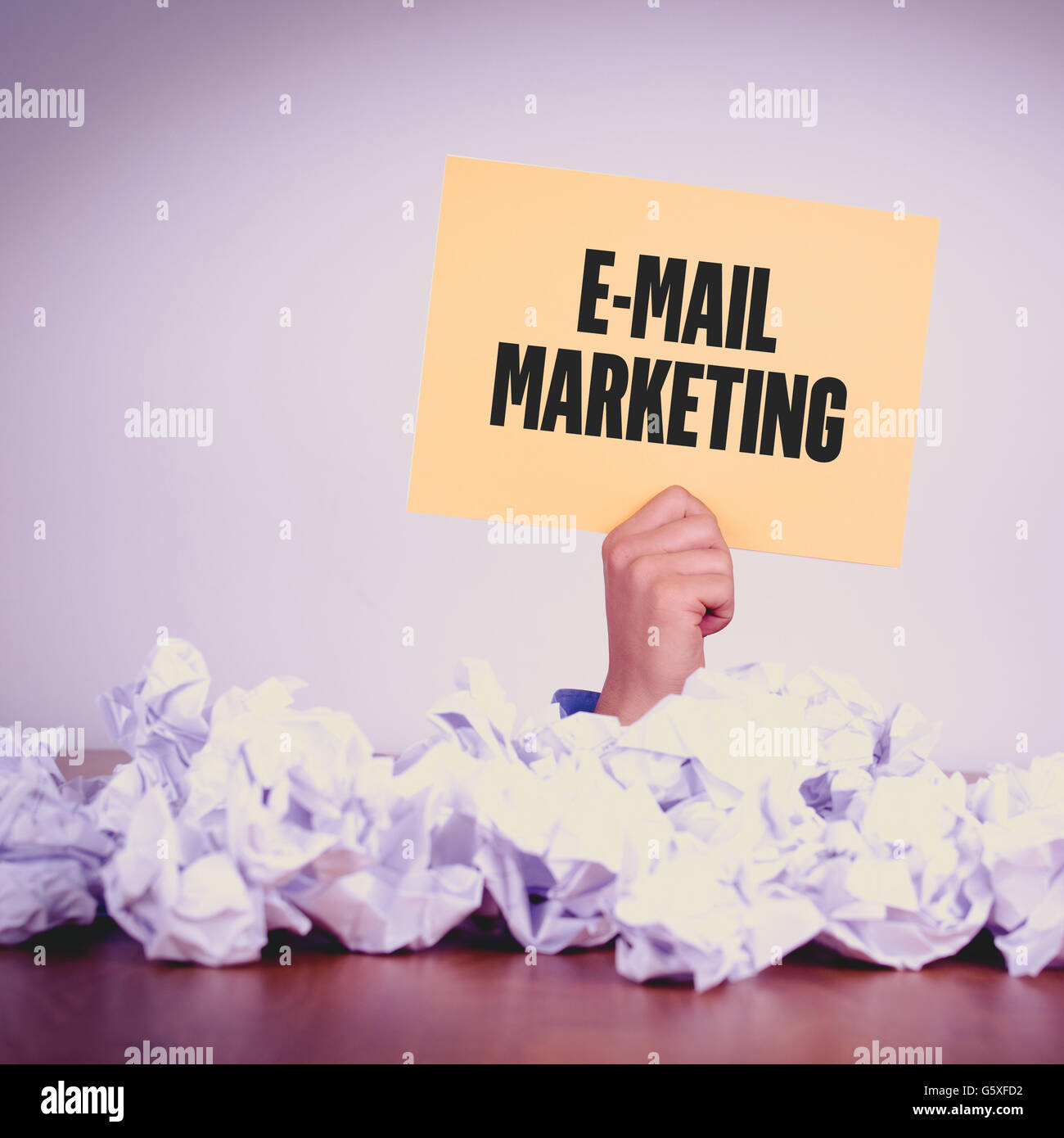 HAND HOLDING YELLOW PAPER WITH E-MAIL MARKETINGCONCEPT Stock Photo