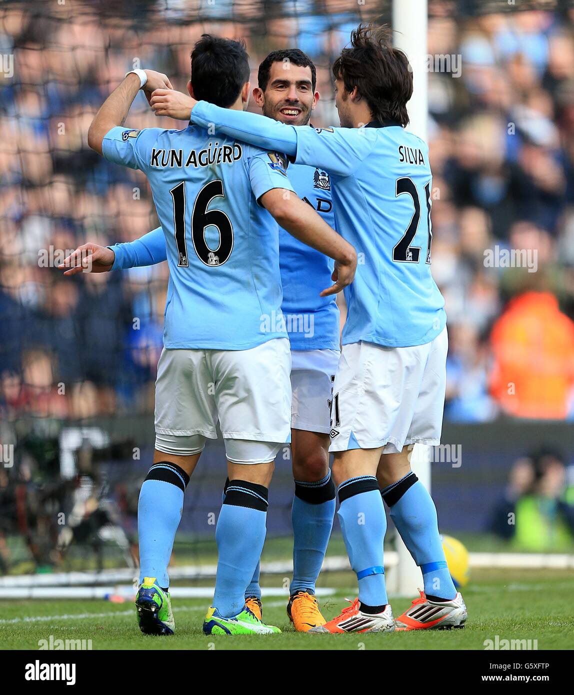 Manchester City's Carlos Tevez (left) celebrates with team-mates Sergio Aguero (left) and David Silva after scoring his side's third goal of the game Stock Photo