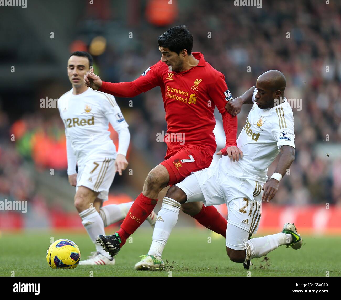 Liverpool's Luis Suarez (centre) and Swansea City's Dwight Tiendalli (right) battle for the ball Stock Photo