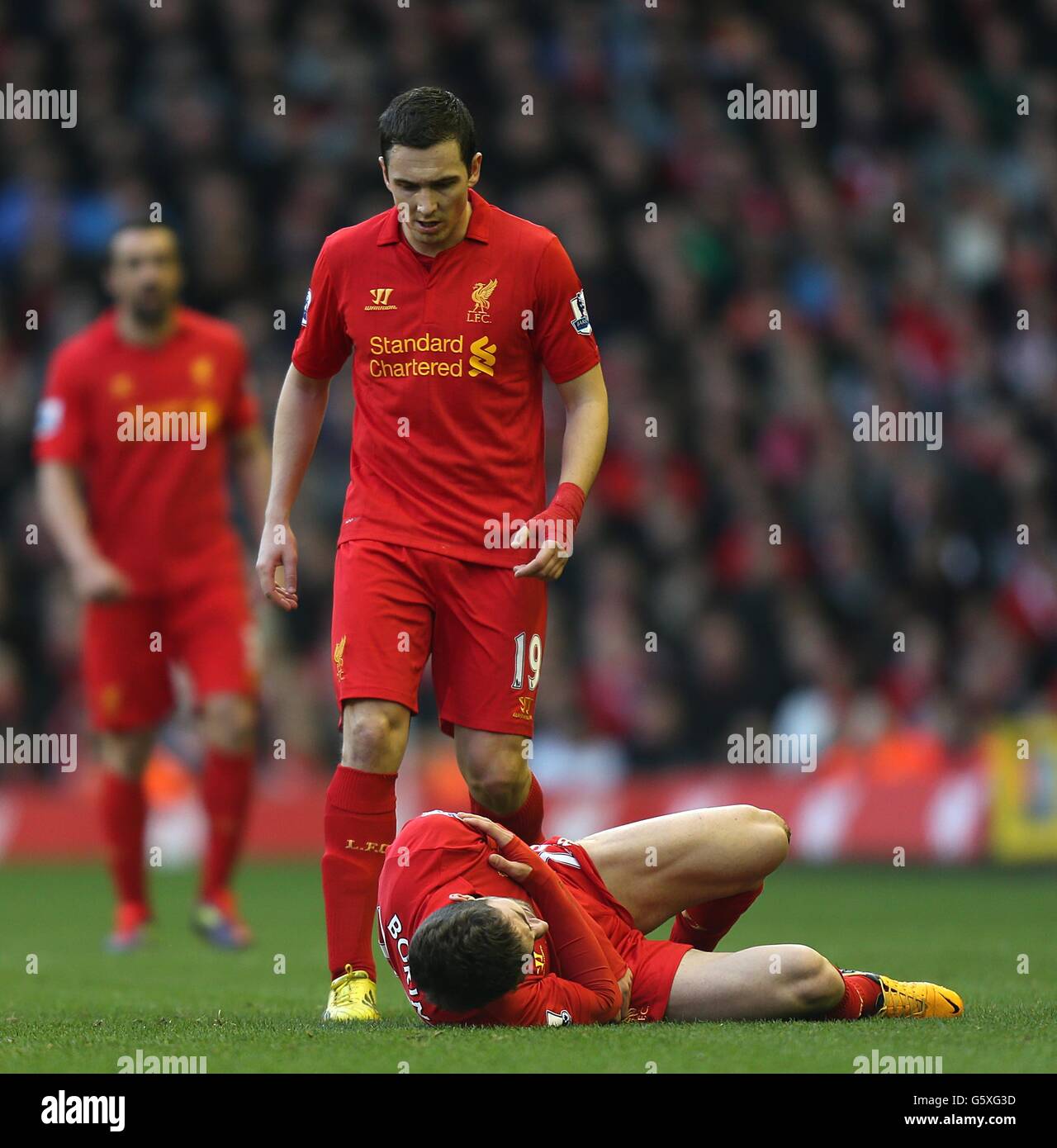 Liverpool's Stewart Downing (top) looks down as teammate Fabio Borini lies clutching his shoulder injured on the ground Stock Photo