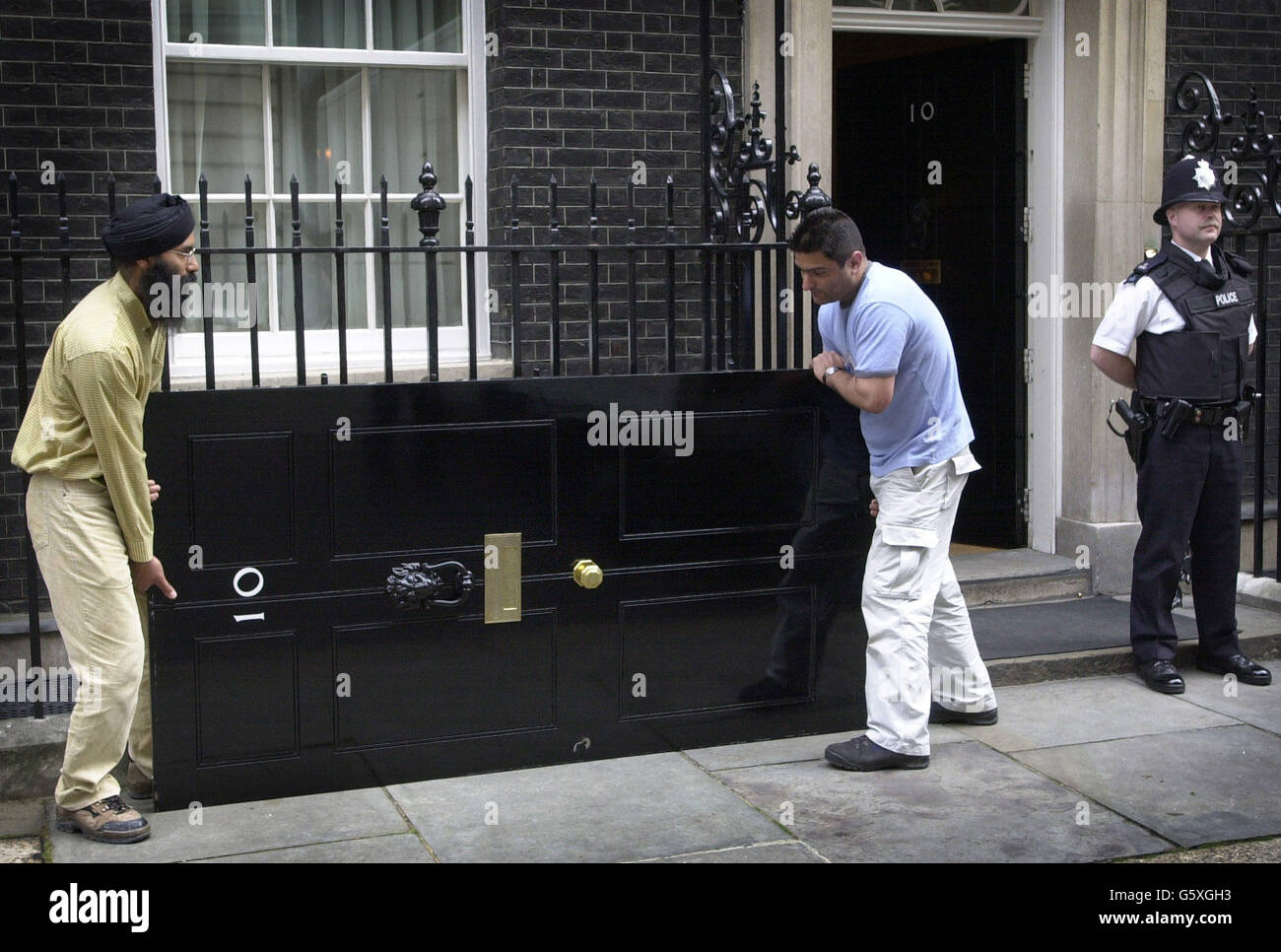 The famous front door of No. 10 Downing Street, the official London recidence of the British Prime Minister, being removed for a new coat of paint. The door is replaced with an exact replica for one year where the process is repeated. Stock Photo