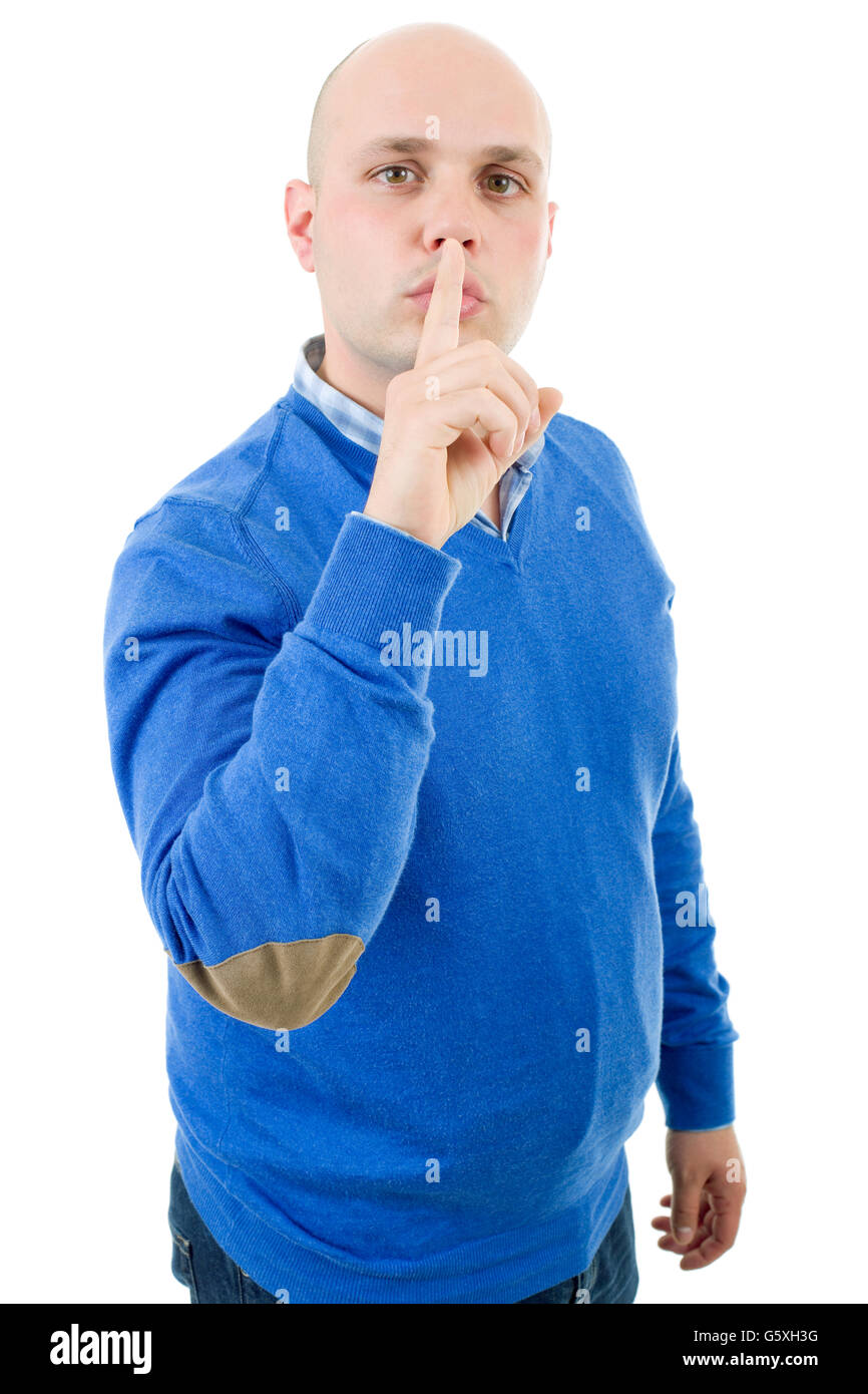 portrait of a young bald man making a shushing gesture with his finger, isolated on a white studio background. Stock Photo
