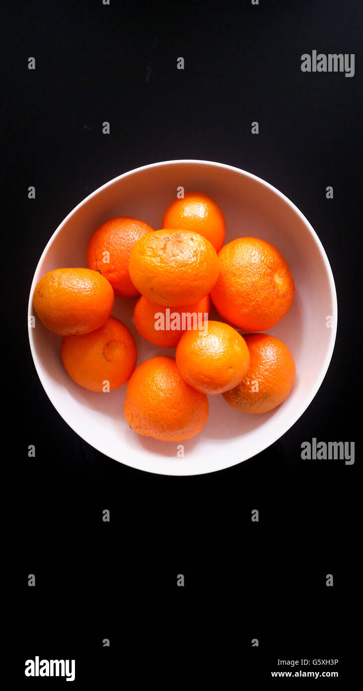Tangerines in a White Bowl on a Black Background Stock Photo