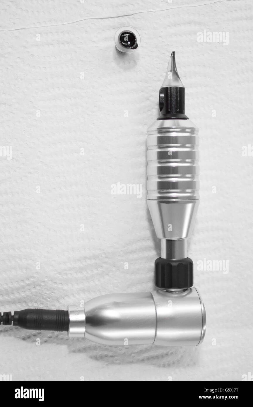 Tattoo machine and ink cup Stock Photo Alamy
