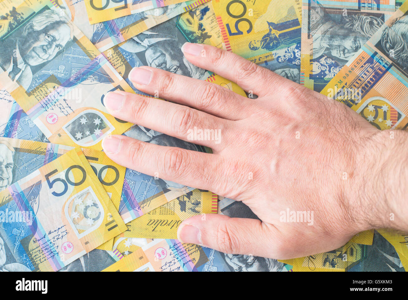 Man's hand on Australian Dollar banknote Stock Photo
