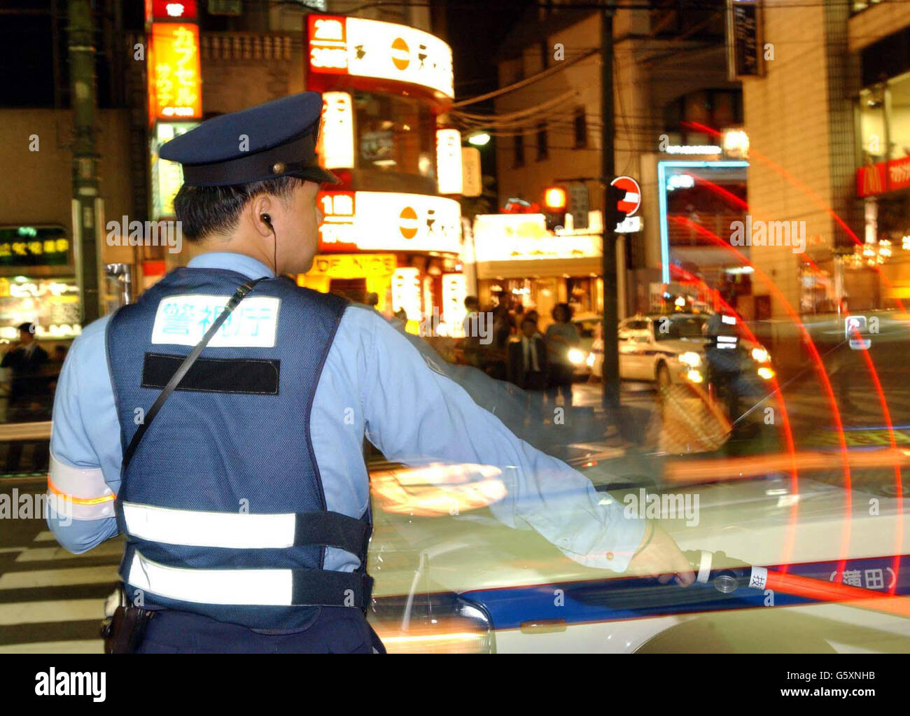 Japanese police officer guarding people on the street in Roppong, Japan. Stock Photo