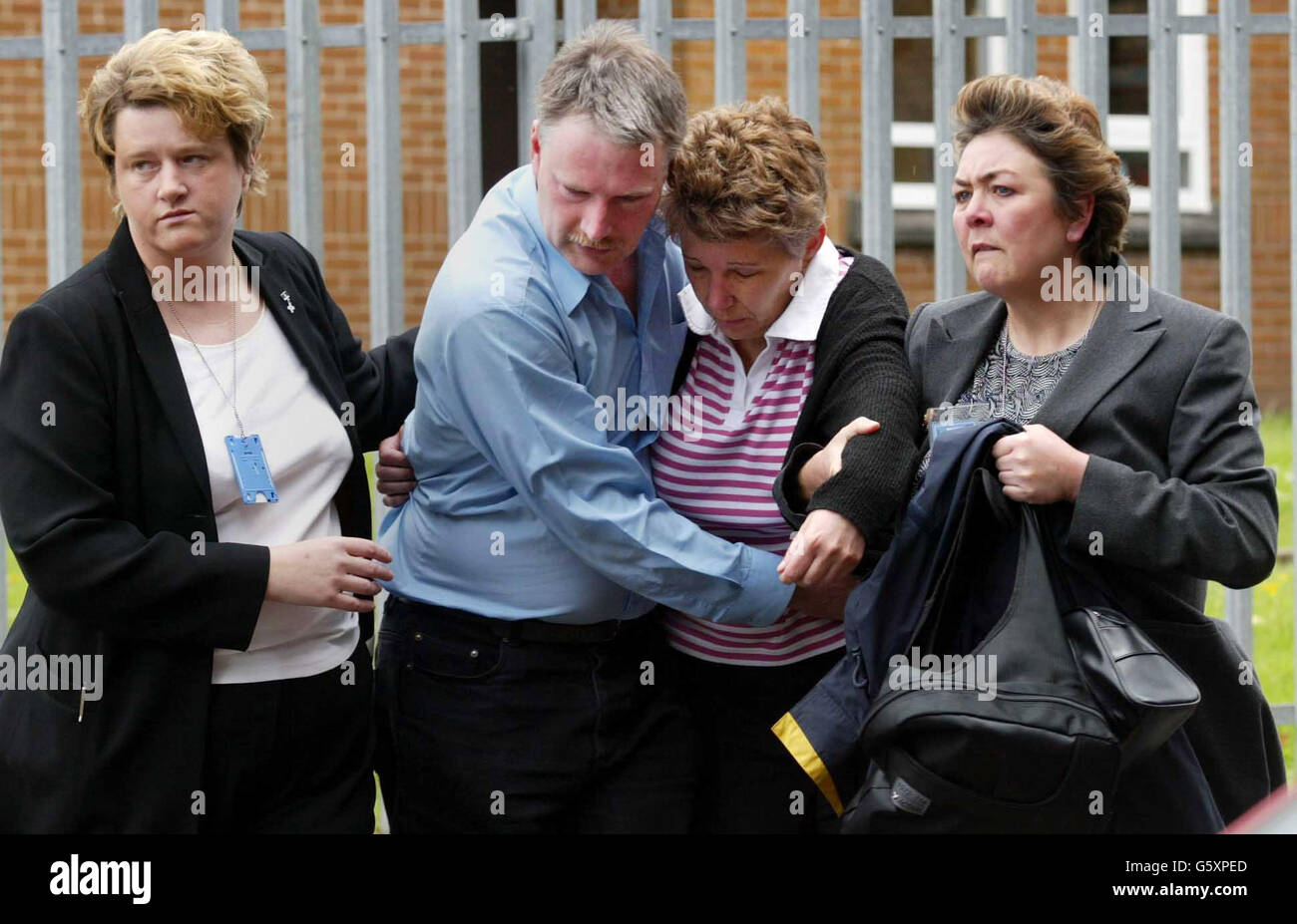Ian and Kaye Fish (centre), parents of 15-year-old Katherine Fish, who died in the coach crash while on a school trip in central France leave Largs Academy with unidentified supporters. Stock Photo