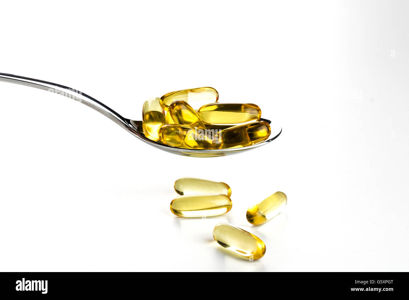 Spoonful of gel capsules of omega 3 Stock Photo