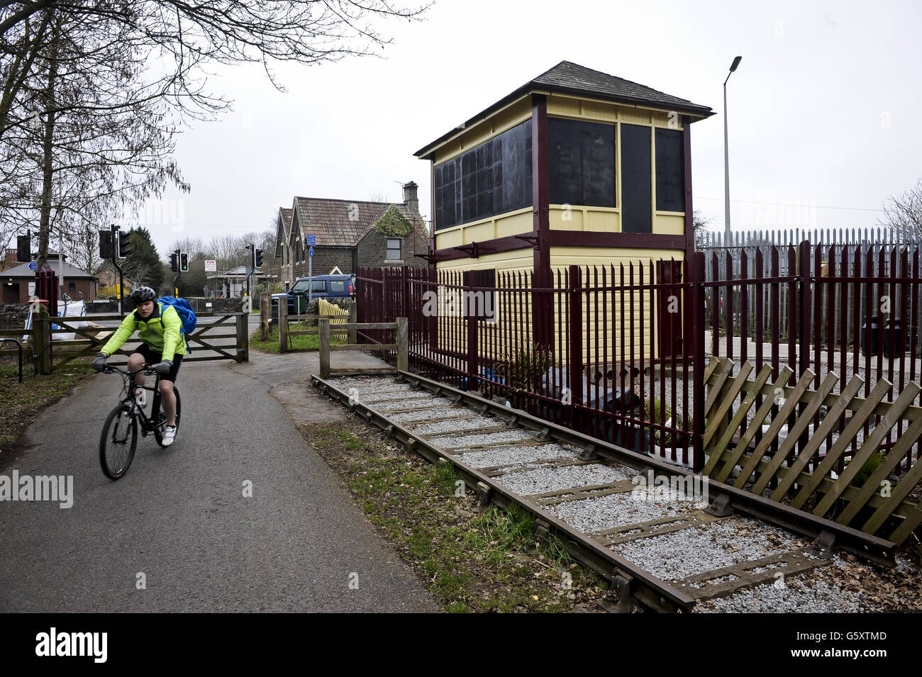 A cyclist passes the restored and preserved Warmly signal box on the Bristol & Bath railway path, Warmly. The Bristol & Bath Railway Path was constructed on the track bed of the former Midland Railway which closed for passenger traffic at the end of the 1960s. Between 1979 and 1986, the railway line was converted into the Railway Path by cycling charity Sustrans. The first stretch was between Bath and Bitton where the campaign group, Cyclebag obtained planning permission to create the 2m wide dust track. The route then developed westwards with Bristol being the last section. This was tarmaced Stock Photo