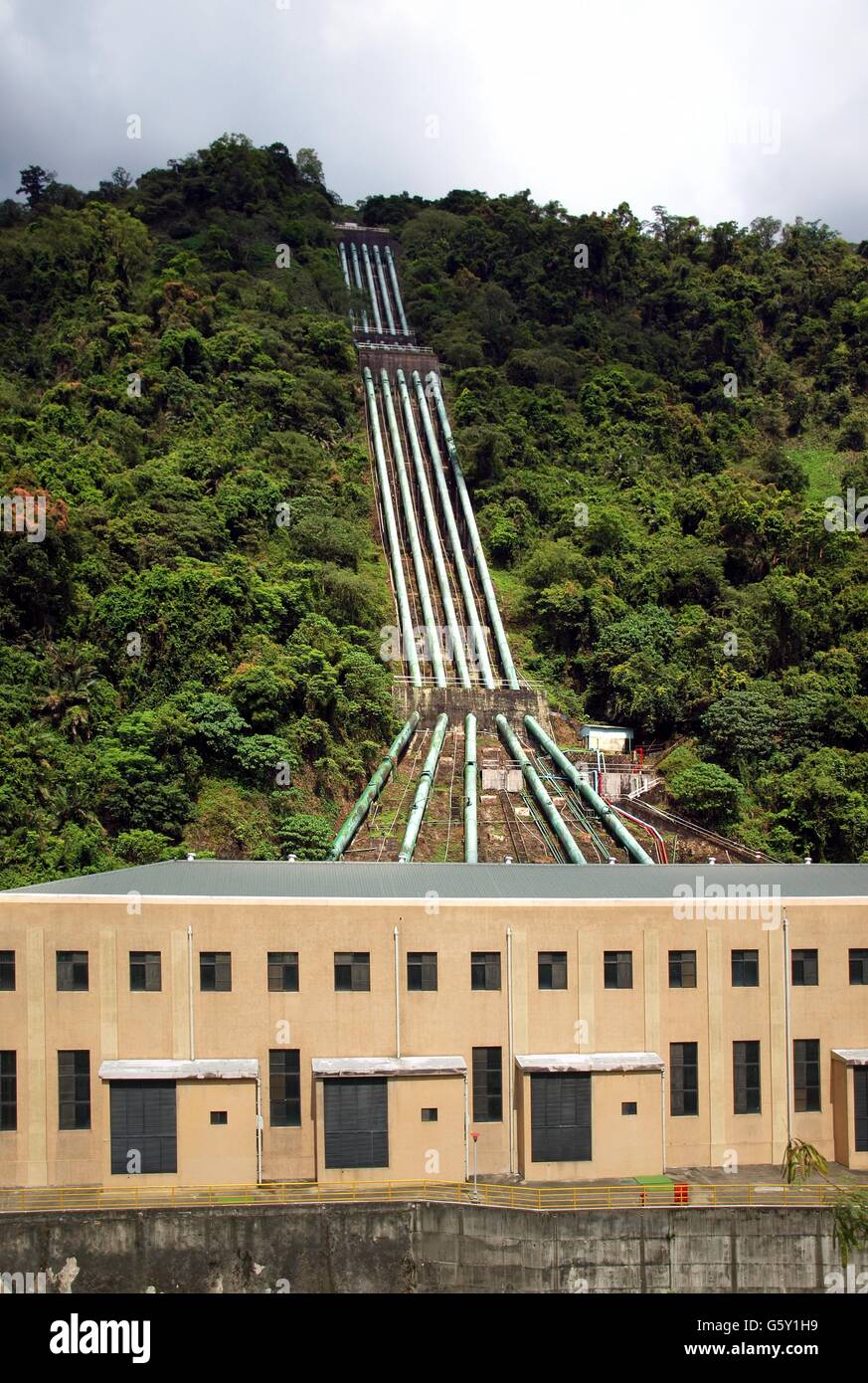 Hydroelectric plant with penstockpipes delivering water to a building housing turbines and generators Stock Photo