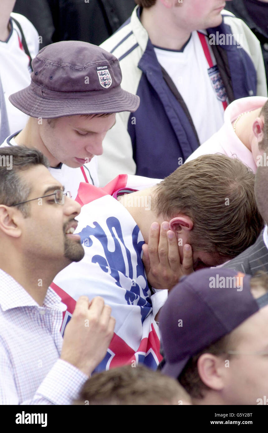 England football fans look distraught in Trafalgar Square in central London, as their team go out to Brazil in the Quarter-Final tie of the World Cup. *The game, played in Japan's Stadium Ecopa in Shizuoka, was the first time that the two teams have met in the World Cup since Brazil's 1-0 defeat of England in the infamous Mexican World Cup of 1970. Stock Photo