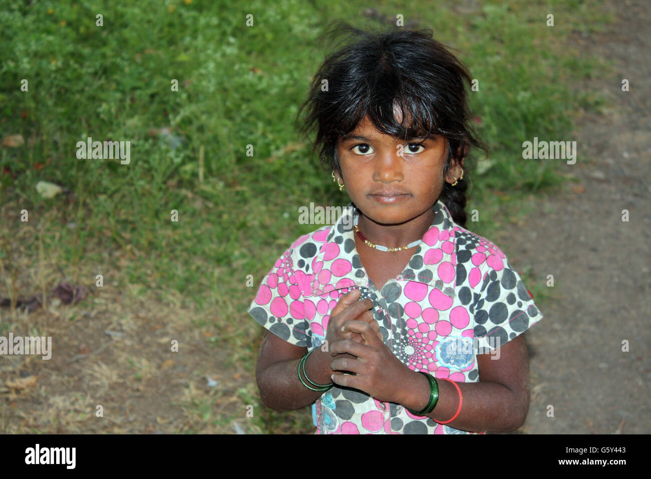 A poor Indian village girl covered with dirt, in the outdoors. Stock Photo