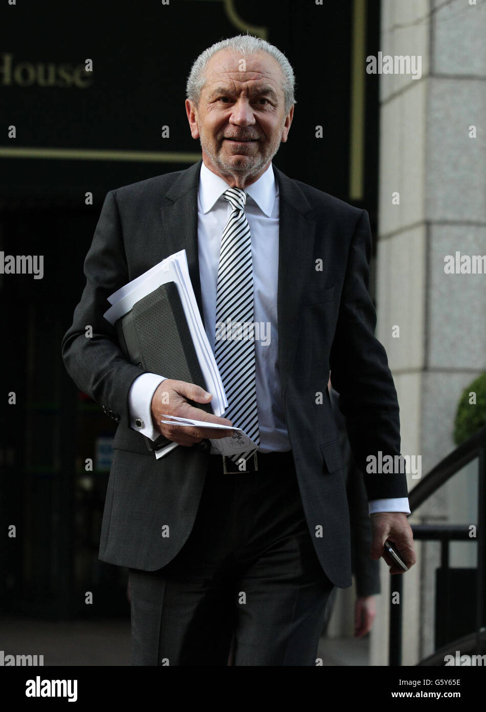 Lord Sugar leaving following a constructive dismissal hearing against him at an East London Employment Tribunal Service at Anchorage House in East India Quay, London. Stock Photo