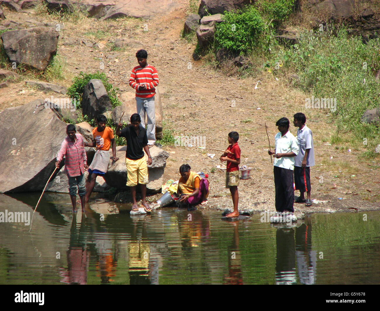 Poor people fishing in a river in India Stock Photo - Alamy