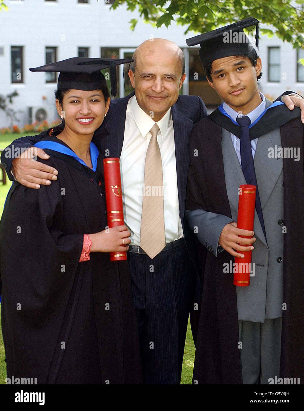 Two of Britain's youngest graduates, brother and sister Iskander, 15, (right) and Noraisha Yusof, 19, with their father Farooq as they graduate from Warwick University with first-class degree with honours and 2-2 Maths degrees respectively. *... The two siblings made academic history when they became the youngest brother and sister to attend university after being taught at home by their mathematician father and their mother, who is a chemistry researcher. Stock Photo