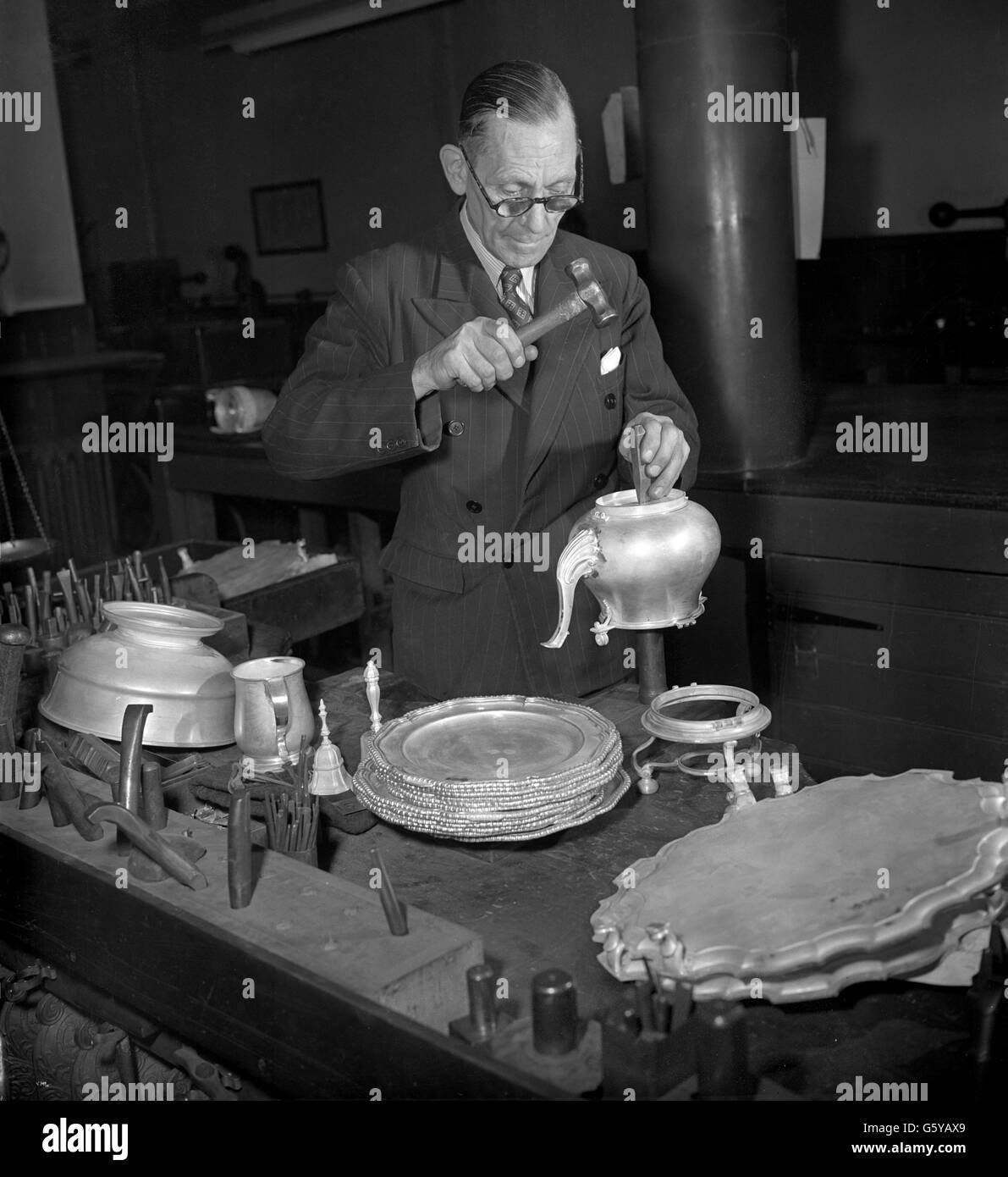 A craftsman applying the hallmark for Coronation year at the Assay Office of Worshipful Company at Goldsmiths' Hall. The special mark, approved by the Queen, is applied to silver and gold made in Britain for sale during 1953. Stock Photo