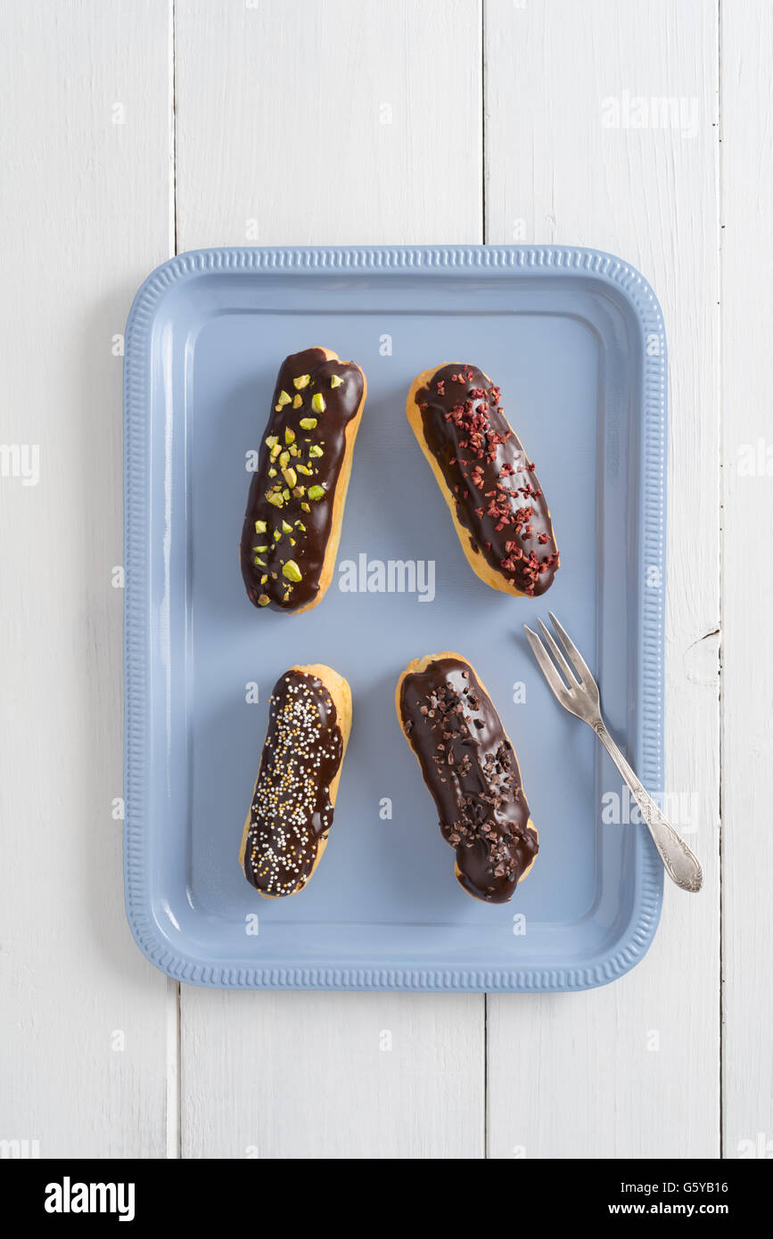 Chocolate eclairs with toppings Stock Photo