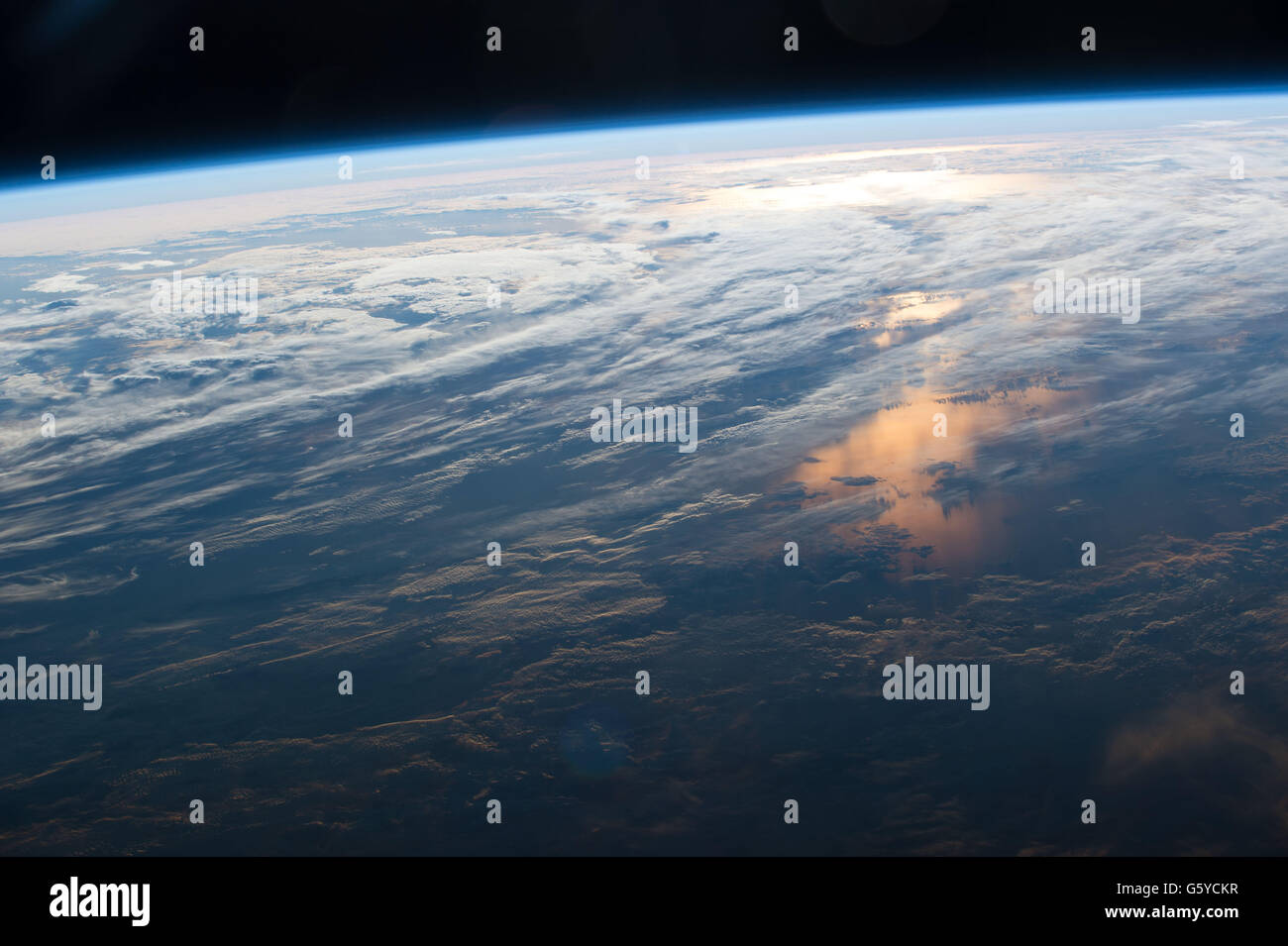 International Space Station Earth observation image captured by Expedition 48 crew members showing the sun reflecting off the ocean and the thin layer of atmosphere protecting the Earth from space. Stock Photo