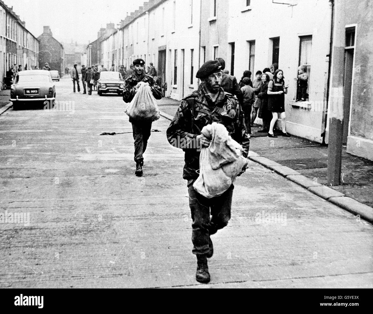 Men of 1st Battalion Welsh Guards carry a bag of gelignite they found in a 'bomb factory' they uncovered in a terrace house in the city's Keegan Street during a dawn swoop. *Picture taken by Gareth Cole, Welsh Guards.* Stock Photo