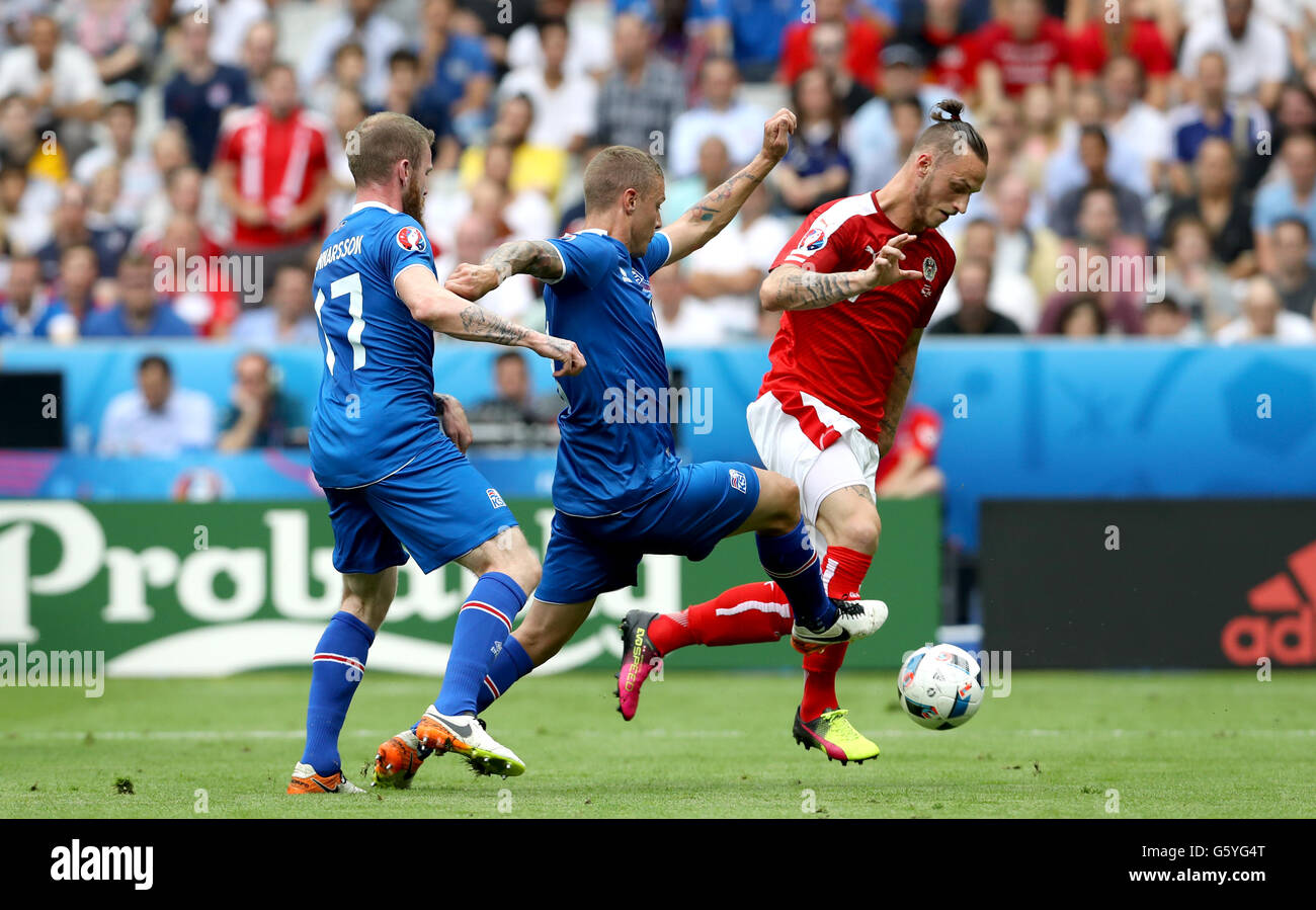 Iceland's Ragnar Sigurdsson (centre) and Austria's Marko Arnautovic (right) battle for the ball during the Euro 2016, Group F match at the Stade de France, Paris. Stock Photo