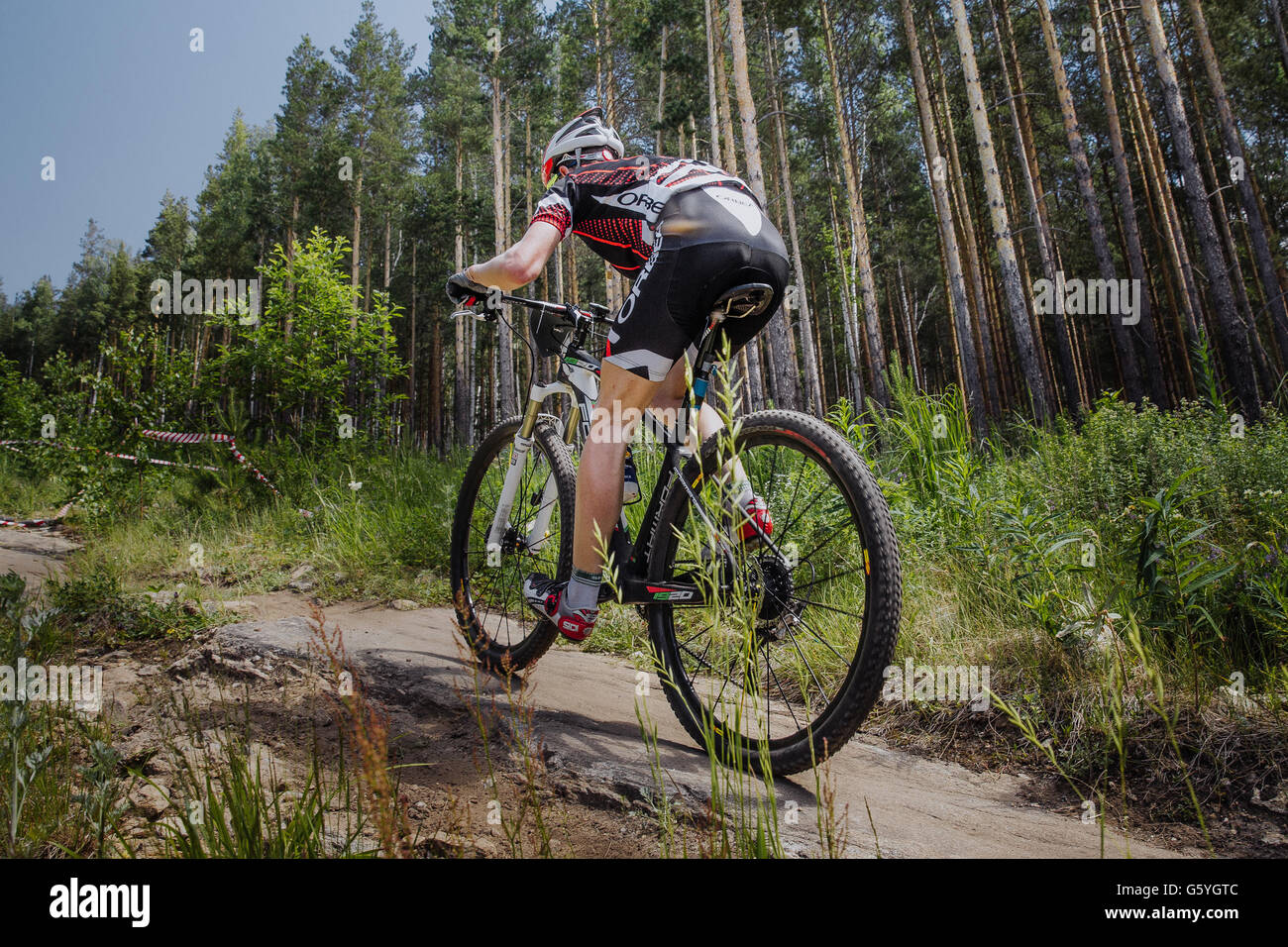 male cyclist riding a bike on forest trail during Championship of Russia on mountain bike Stock Photo