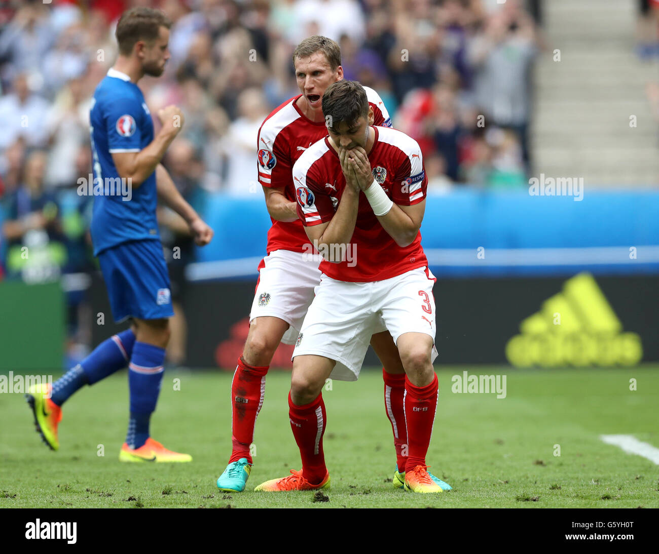 Austria's Aleksandar Dragovic is consoled by teammate Florian Klein (left) after missing a penalty during the Euro 2016, Group F match at the Stade de France, Paris. Stock Photo