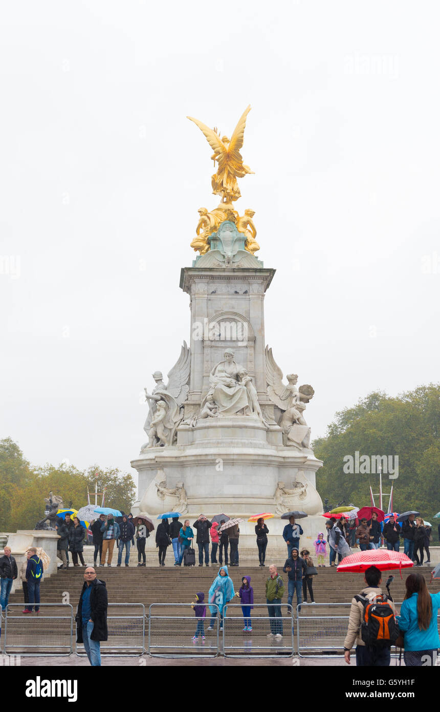 LONDON, ENGLAND - OCTOBER 21, 2015: Unknown tourists in front of the queen Victoria memorial waiting for the horse parade to com Stock Photo