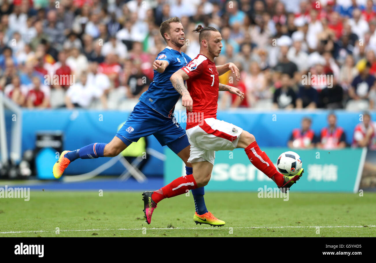 Iceland's Kari Arnason (left) and Austria's Marko Arnautovic battle for the ball during the Euro 2016, Group F match at the Stade de France, Paris. Stock Photo