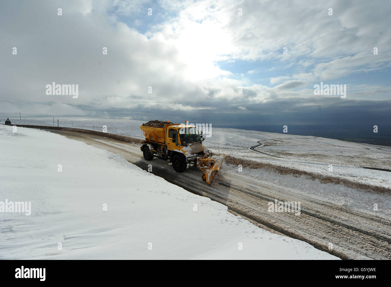 A snow plough clears the road near Hartside in Cumbria after more heavy snow hit the region. Stock Photo
