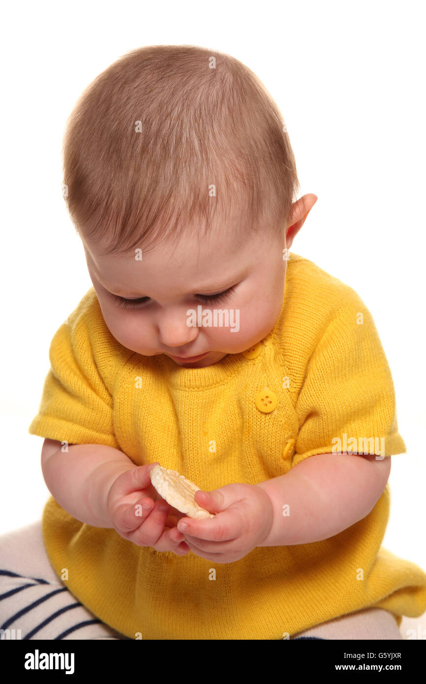 Baby girl eating finger food cutout Stock Photo