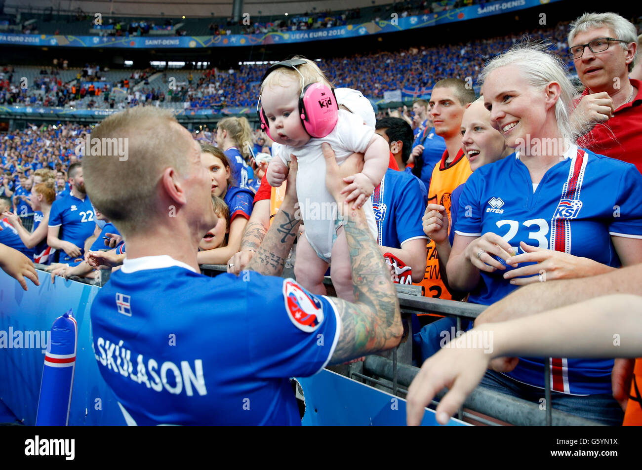 Iceland's Ari Freyr Skulason holds a baby from the crowd as he celebrates qualifying for the last 16 round after the Euro 2016, Group F match at the Stade de France, Paris. after qualifying for the last 16 round after the Euro 2016, Group F match at the Stade de France, Paris. PRESS ASSOCIATION Photo. Picture date: Wednesday June 22, 2016. See PA story soccer Iceland. Photo credit should read: Owen Humphreys/PA Wire. Stock Photo
