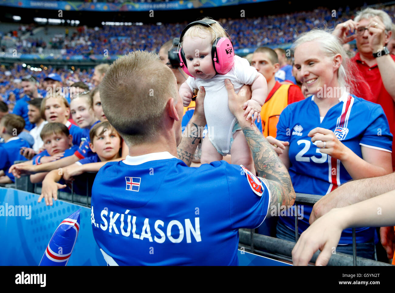 Iceland's Ari Freyr Skulason holds a baby from the crowd as he celebrates qualifying for the last 16 round after the Euro 2016, Group F match at the Stade de France, Paris. after qualifying for the last 16 round after the Euro 2016, Group F match at the Stade de France, Paris. PRESS ASSOCIATION Photo. Picture date: Wednesday June 22, 2016. See PA story SOCCER Iceland. Photo credit should read: Owen Humphreys/PA Wire. RESTRICTIONS: Use subject to restrictions. . Book and magazine sales permitted providing not solely devoted to any one team/player/match. No commercial use. Call +44 (0)1158 Stock Photo