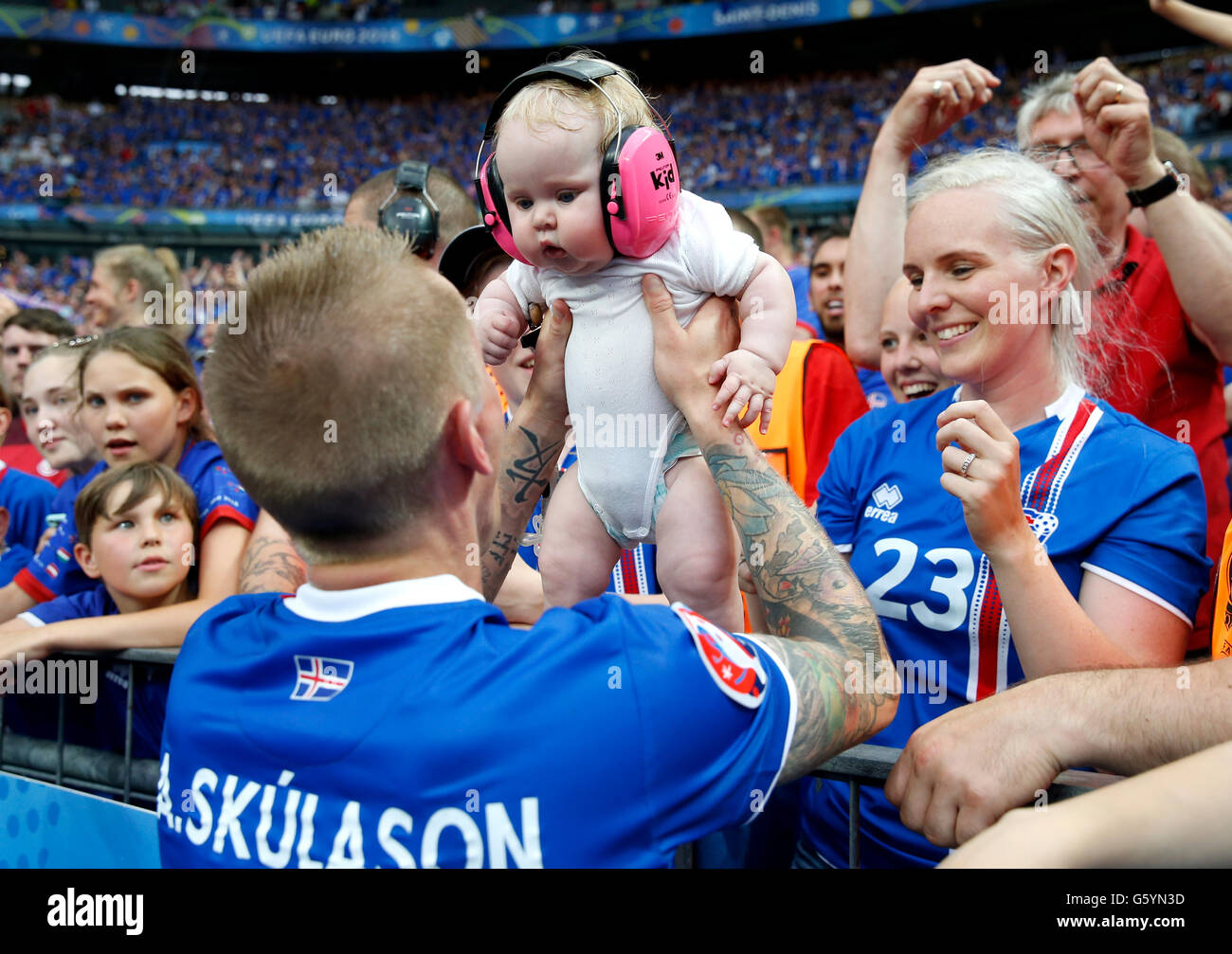 Iceland's Ari Freyr Skulason is handed a baby from the crowd as he celebrates qualifying for the last 16 round after the Euro 2016, Group F match at the Stade de France, Paris. after qualifying for the last 16 round after the Euro 2016, Group F match at the Stade de France, Paris. PRESS ASSOCIATION Photo. Picture date: Wednesday June 22, 2016. See PA story SOCCER Iceland. Photo credit should read: Owen Humphreys/PA Wire. Stock Photo