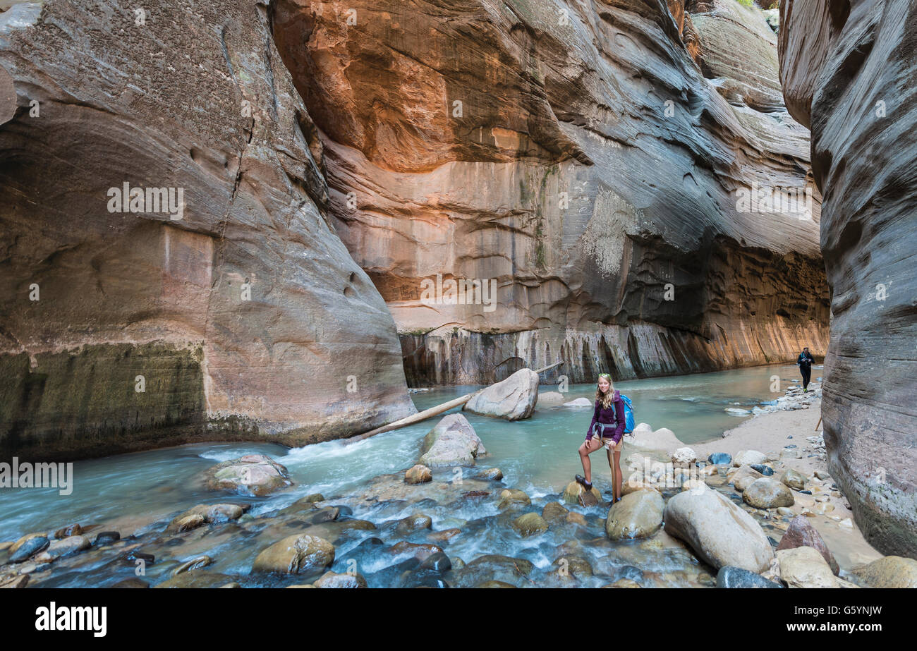 Hiker standing in river, Zion Narrows, narrow of the Virgin River, steep faces of Zion Canyon