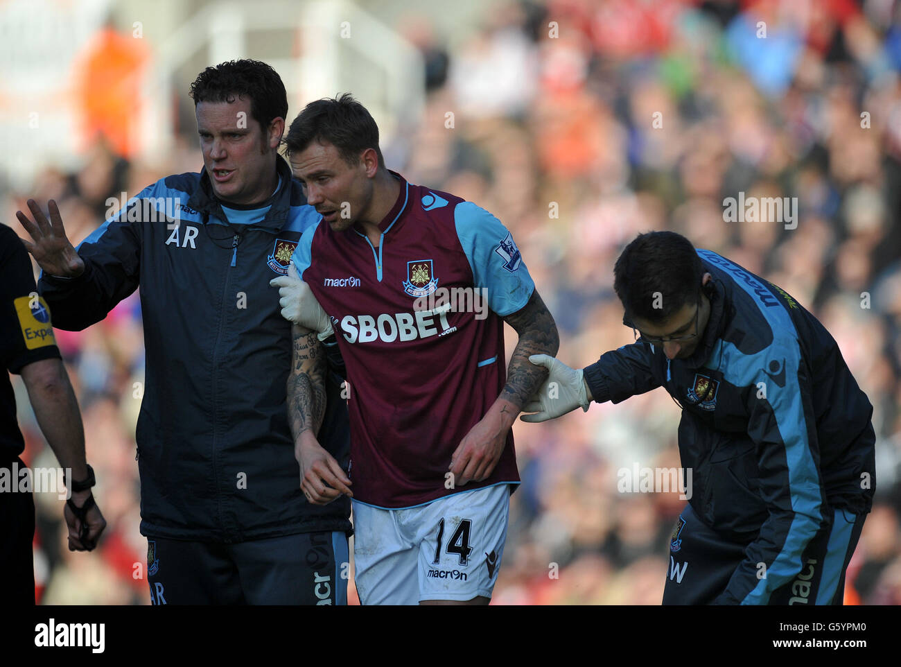 West Ham United's Matthew Taylor is helped off after a clash with Stoke City's Peter Crouch during the Barclays Premier League match at the Britannia Stadium, Stoke. Stock Photo