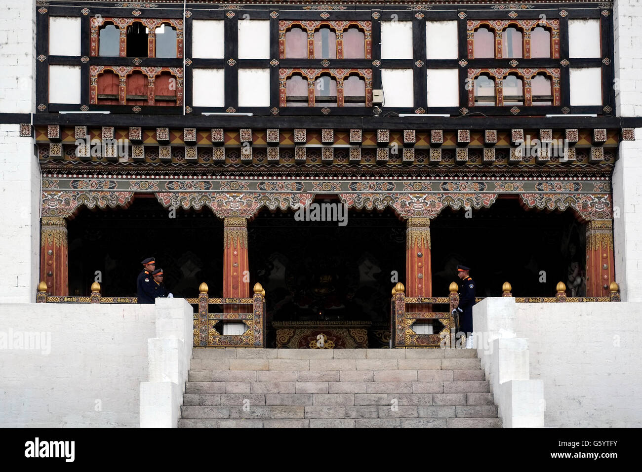 Sentries stand firm at the entrance to the government offices in Tashichho Dzong fortress seat of Bhutan's government since 1952 and presently houses the throne room and offices of the king on the edge of the city of Thimphu the capital of Bhutan Stock Photo