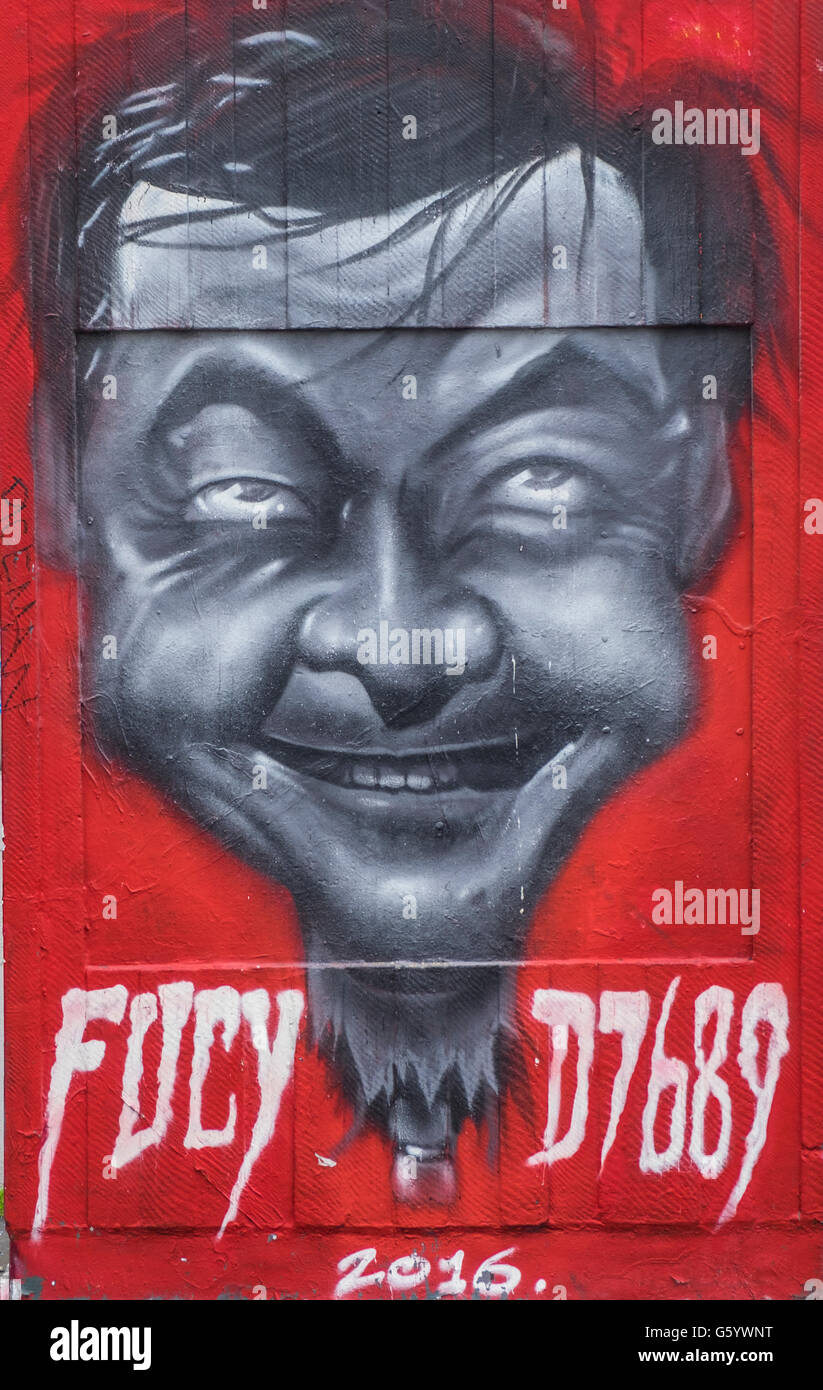 A wall art painting of a mans face on a red background. Stock Photo