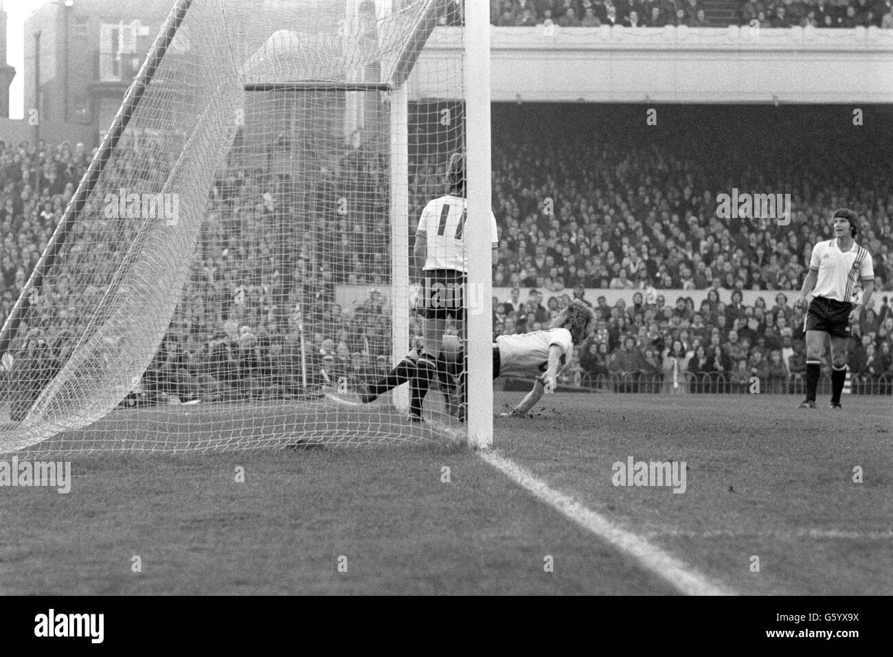 Manchester United's Brian Greenhoff bends over backwards in an attempt to avert disaster, but puts the ball into his own net during a First Division match against Arsenal. Stock Photo