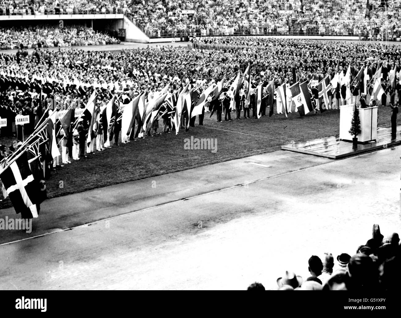 Headed by their national flags, athletes from all corners of the world take the Olympic Oath at the opening of the Olympic Games in Helsinki. Stock Photo
