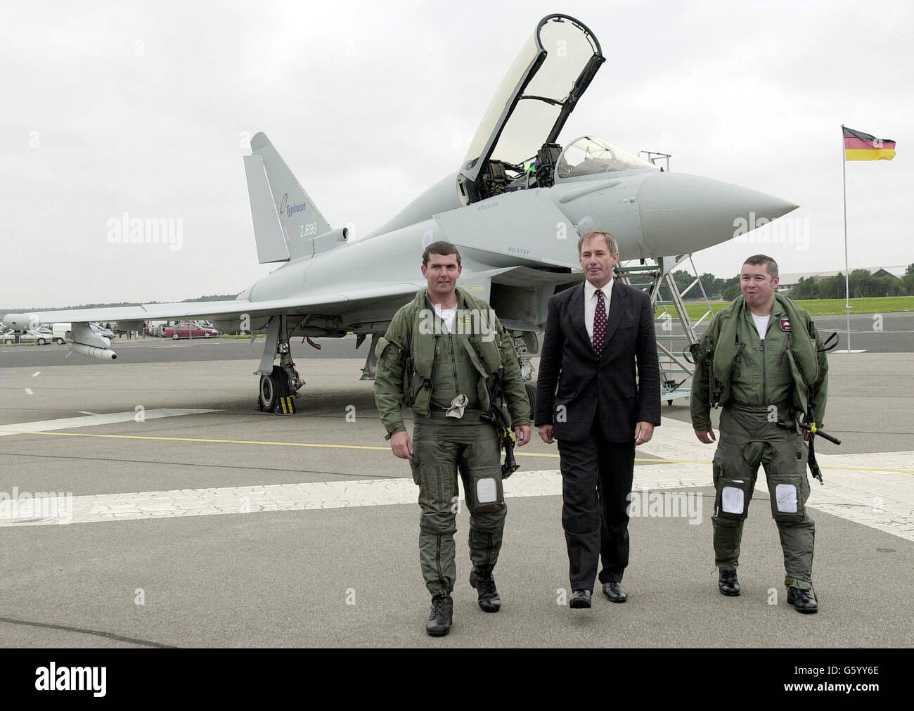 Defence Secretary Geoff Hoon meets the new RAF Typhoon's air crew, Craig Penrice (left) and Wing Commander David 'Charlie' Chan after the aircraft took part in a formation flypast. *....Four RAF Eurofighters flew over Farnborough Airshow in a display before the plane was officically named Typhoon by Mr Hoon. The first Typhoon is due to be delivered to the RAF by the end of this year. Stock Photo
