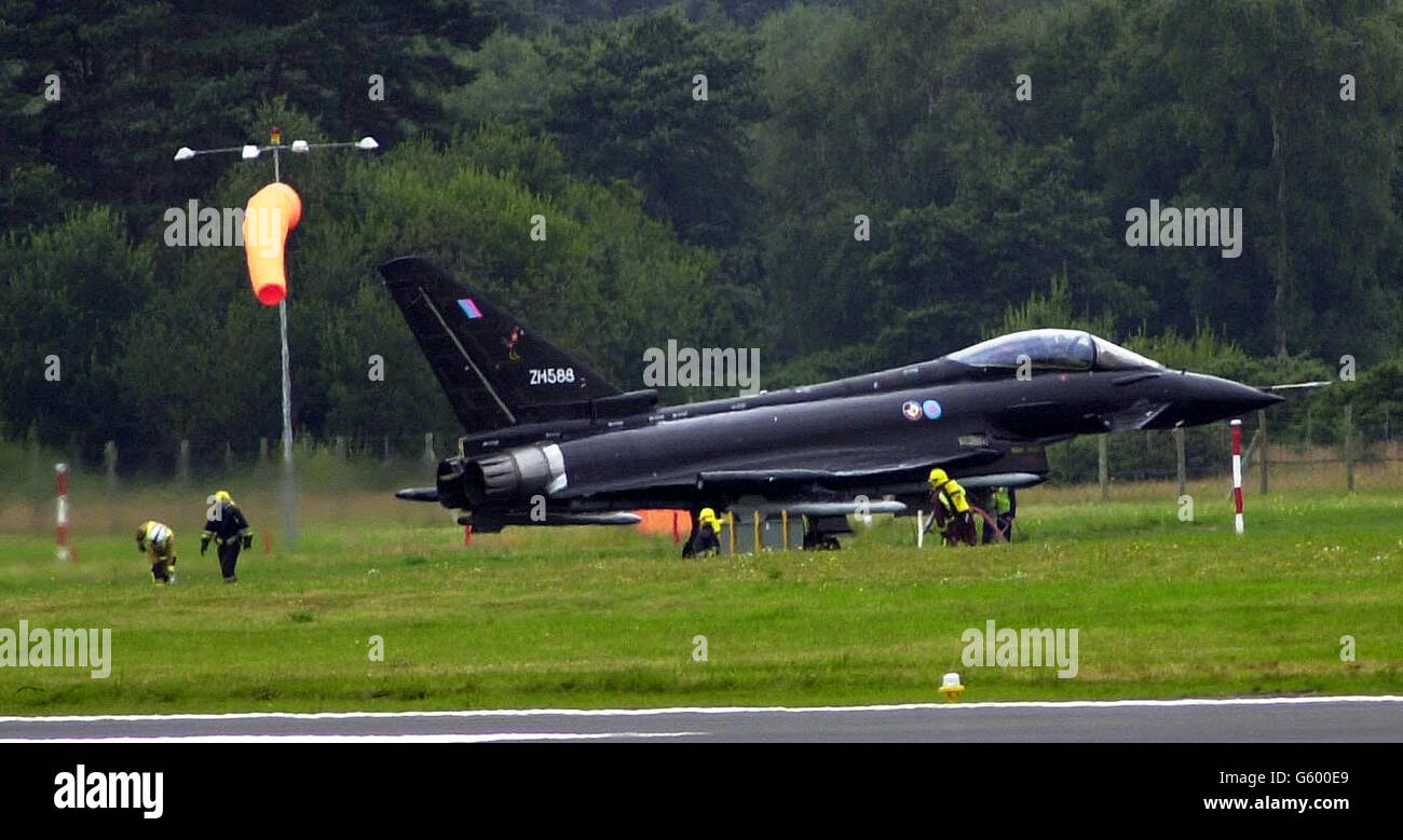 Firemen around Britains new Typhoon (Eurofighter) as a Smoke Pod fails to go out when the fighter landed after the Typhoons display at the Farnborough Airshow. The inncident halted the show for a few minutes as firemen checked the aircraft. Stock Photo