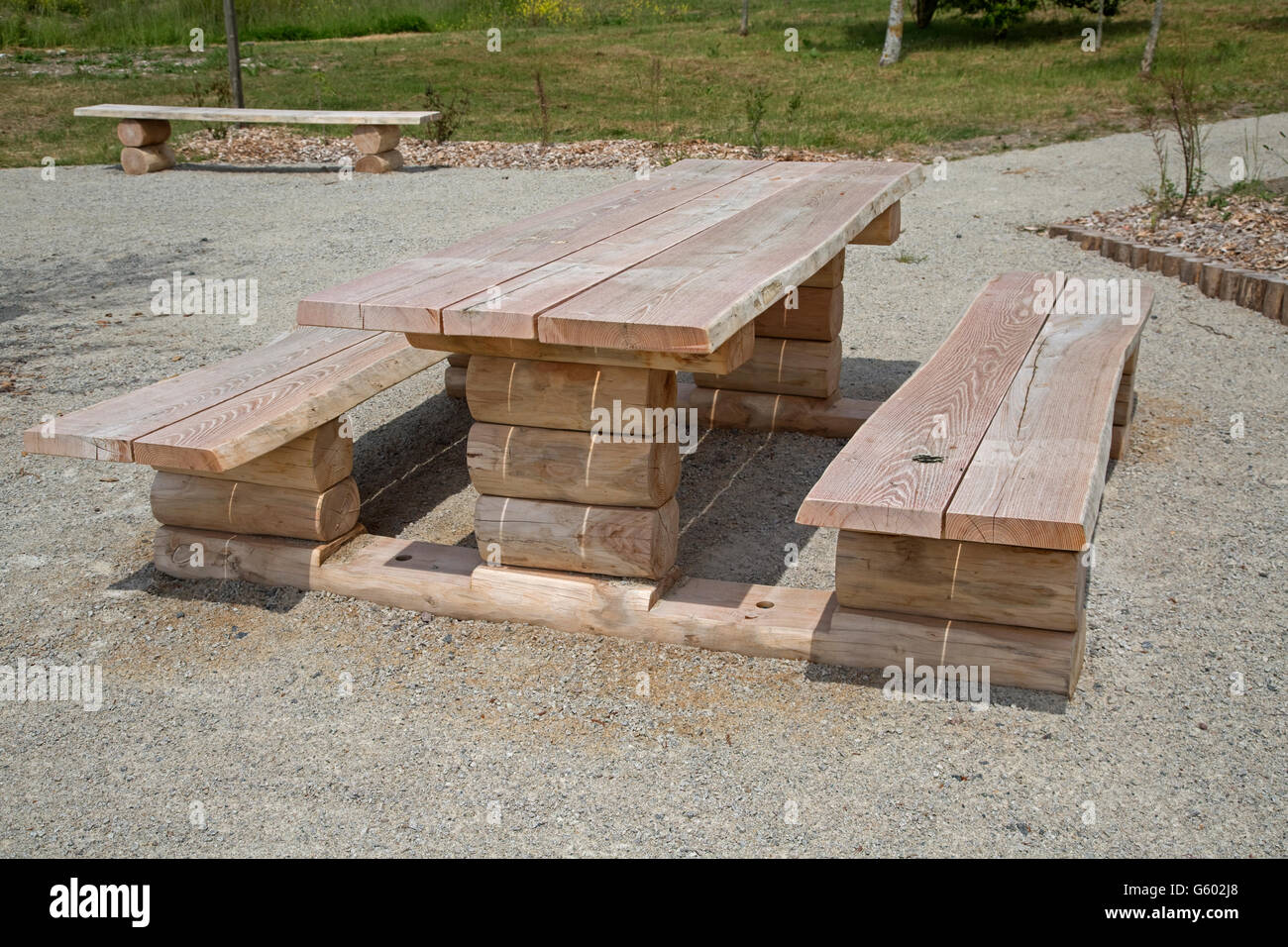 Rustic outdoor log picnic table bench seats with no people Vendee near Bouin France Stock Photo