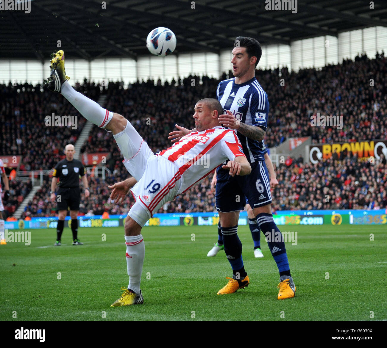 Stoke City's Jon Walters ficks the ball over the head of West Bromwich Albion's Liam Ridgewell during the Barclays Premier League match at the Britannia Stadium, Stoke. Stock Photo