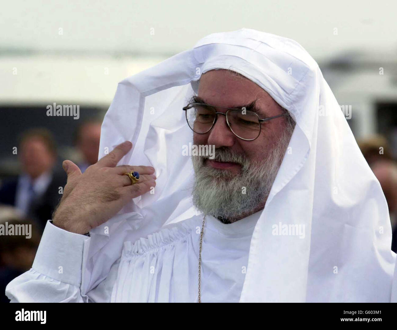 The next Archbishop of Canterbury, Dr Rowan Williams, in head gear at his induction as a Druid, during a ceremony at the Eisteddfod near St David's, Pembrokeshire, Wales. The ceremony, which took more than an hour, started with a procession from the main Eisteddfod Pavilion to a circle of stones on the edge of the site. The actual ceremony started with a trumpet fanfare and the partial sheathing and unsheathing of a 6ft 6ins sword. Hymns and poems were said in Welsh before around 50 people were made druids. Stock Photo