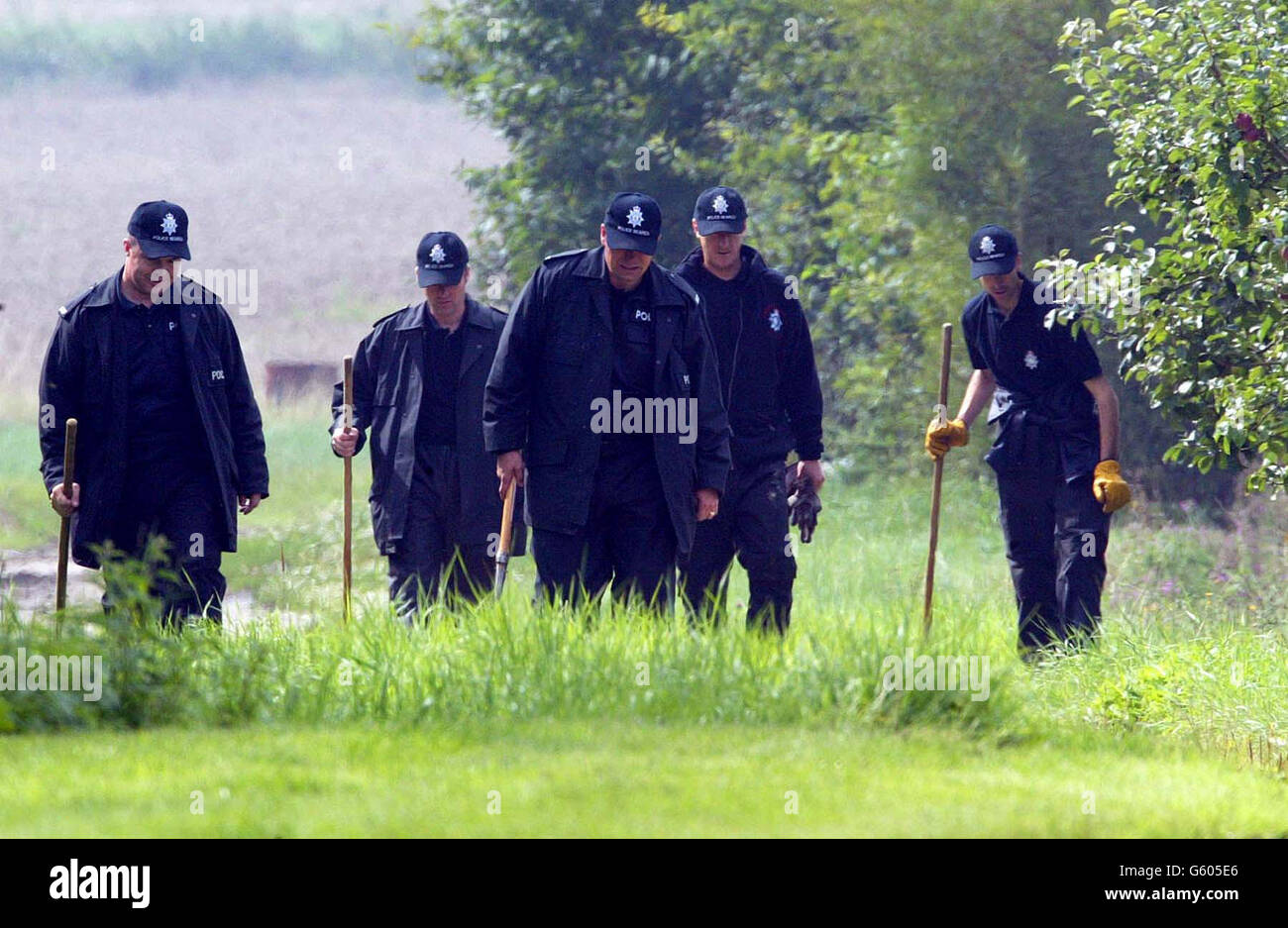 Police continue to search for evidence on missing 10-year-old girls, Holly Wells and Jessica Chapman at a farm yard in Wicken, near Soham, Cambridgeshire. The two girls went missing on Sunday August 4 2002. *... Police have been focusing on sightings of the pair around the town of Soham, where the girls disappeared. Officers are continuing house-to-house inquiries and have begun searching outlying areas of the town, including fields, ditches, drains and waterways. Torrential rain has lashed the town in the past 48 hours and officers have admitted they fear vital evidence could be washed away. Stock Photo
