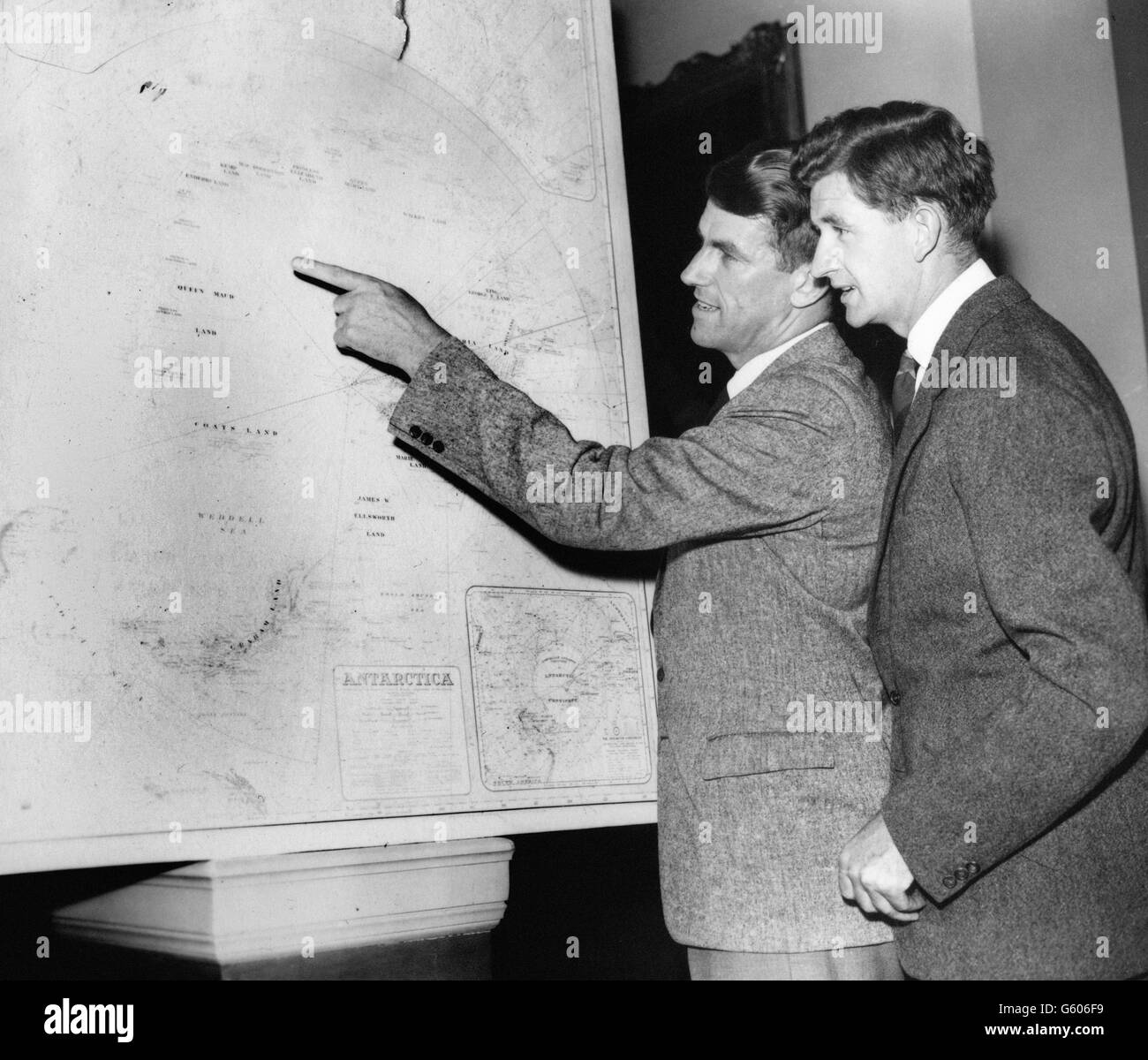 Sir Edmund Hillary (left) and photographer George Lowe at the Royal Geographical Society's headquarters in London. They were discussing their roles in the upcoming British Antarctic Expedition, led by Dr Vivian Fuchs. Stock Photo