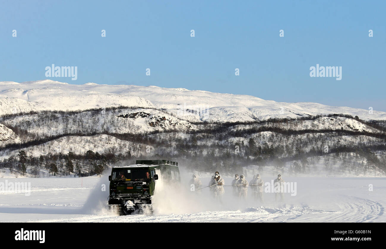 Marines take part in the Skijoring drill which involves them being towed behind the BV-206 vehicle, as troops take part in Exercise Hairspring 2013, which focuses on cold weather survival and warfare training for Royal Marines Commando Reservists in the mountains range near to Porsanger Garrison near Lakselv, Norway. Stock Photo