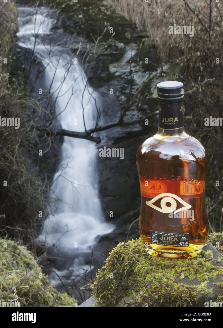 A bottle of Jura Prophecy whisky next to the stream that supplies the water to make the whisky at the Jura whisky distillery on the Scottish island Jura. Master blenders from across the globe will meet in Scotland next month in search of the year's top whisky. Stock Photo