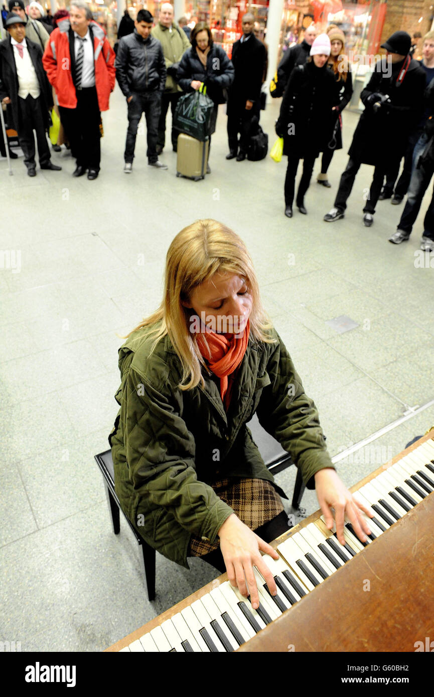 Virtuoso pianist and YouTube star, Valentina Lisitsa, plays to a cluster of commuters on one of the St Pancras' street pianos in the St Pancras Station, London, in the station concourse after her Eurostar train was cancelled due to severe weather conditions affecting the UK and Europe. PRESS ASSOCIATION Photo. Picture date: Tuesday March 12, 2013. Photo credit should read: Nick Ansell/PA Wire Stock Photo