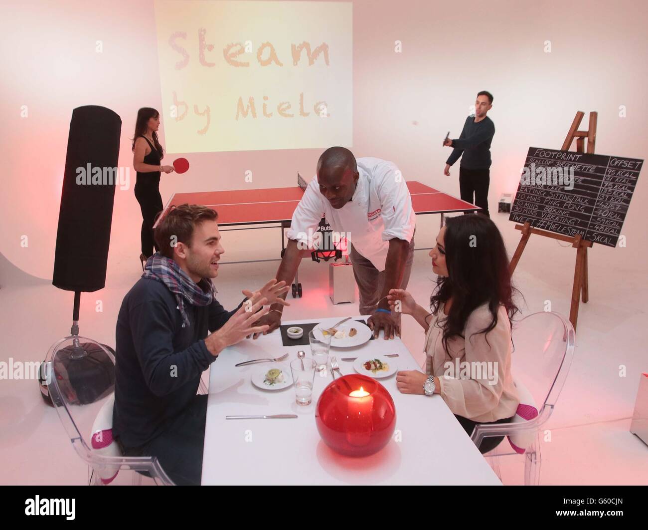 Chef Frederick Forster, centre, serves diners Tom Hills and Farah Hatab during a warm-up ahead of the launch of Steam by Miele, the world's first weight-loss pop-up restaurant in London's Covent Garden. Stock Photo